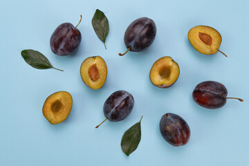 fresh plums isolated on blue background, pattern with ripe fruits