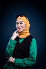 Closeup portrait of a beautiful female Muslim model wearing hijab, a lifestyle apparel for Muslim women isolated on dark grey background. Modern hijab fashion concept.