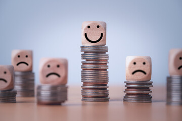 Coin stacking on smiley face and sad face for good financial planing can make happiness in life,...