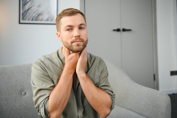 Fototapeta premium Sore throat. Dark-haired young man having a sore throat.