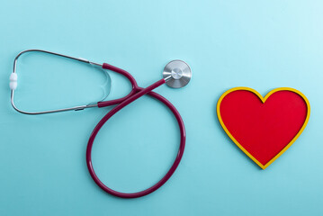 Red heart and stethoscope lies on a blue background