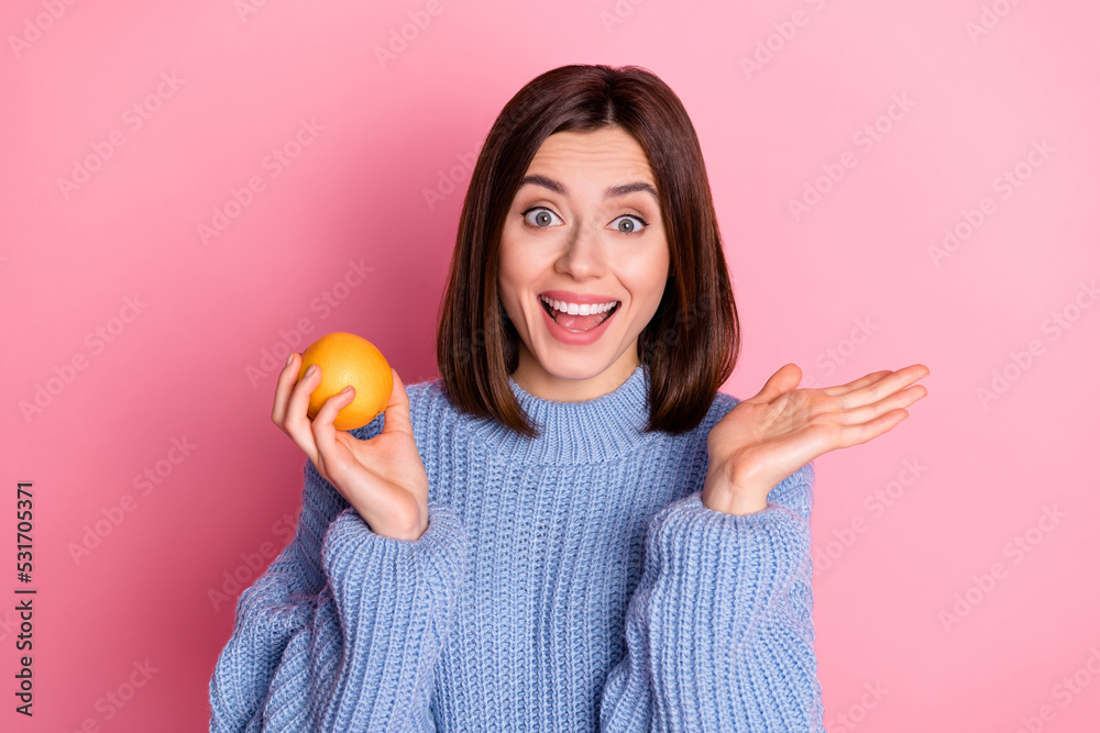 Sticker photo of young crazy smiling girl wear blue knitted sweater hold orange want eat fresh fruits isolat