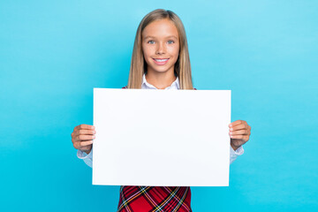 Photo of positive cute girl arms hold demonstrate empty space blank isolated on blue color background