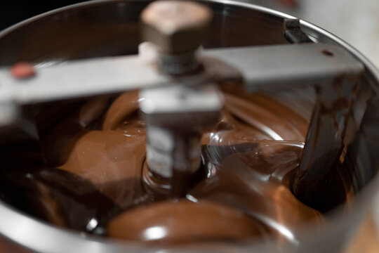 Shiny melting chocolate in processing machine