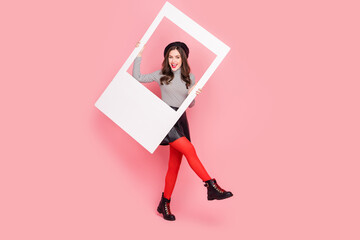 Photo of stylish trendy lady fashionista on fashion week make photo frame wear skirt isolated pink...