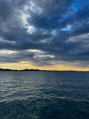 Evening sea view, cloudy sky and yellow sun light, sea horizon 