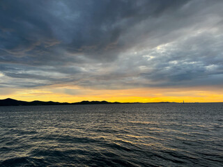 Evening sea view, cloudy sky and yellow sun light, sea horizon 