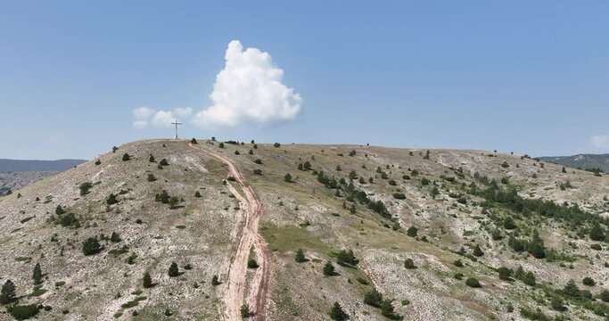 stian Religio Cross Situated On Top Of Mountain Under Blue Sky. Aerial orbiting shoot.