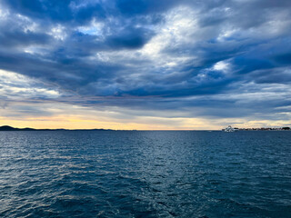 Evening sea view, cloudy sky and yellow sun light, sea horizon 