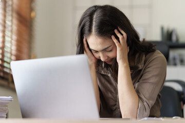 Depressed tired asian businesswoman, stressed at office workplace.