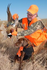 A hunter with a rooster pheasant