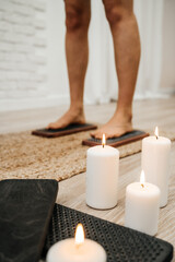 The legs of a girl standing on nails with lit white candles. Sadhu Board. Concept on healthy lifestyle.