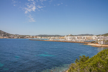 Naklejka na ściany i meble Beautiful seascape of the Mediterranean Sea and rocky coast of Ibiza island with bay of Santa Eulalia del Rio, Spain