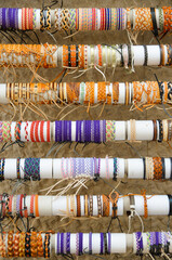 Viele bunte Armbänder aus Stoff und Leder auf dem Markt in Detailansicht