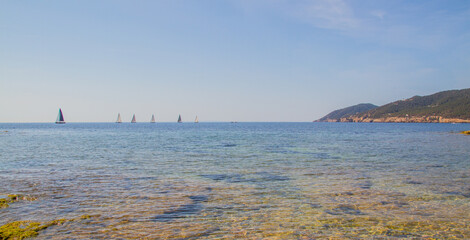 View of the Mediterranean Sea with sailing boats at the horizon near Santa Eulalia del Rio, Ibiza island, Spain