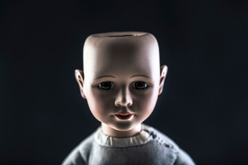 Creepy doll face on dark background