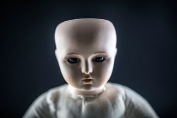 Fototapeta na wymiar Creepy doll face on dark background
