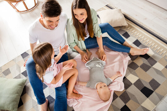 High angle view photo of full peaceful positive family sit carpet floor talk chatting spend pastime indoors
