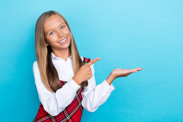Photo of young small pretty nice schoolgirl wear new uniform finger pointing empty space hold palm...