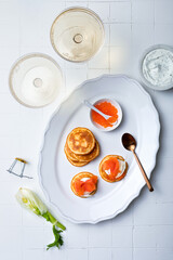 Festive appetizer with champagne glass. Mini Blini pancakes with dill sour cream, salmon, fennel...