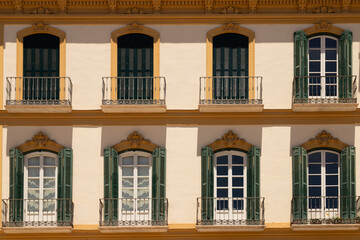 Facade with balconies and shutters of a stately home on Plaza de la Merced in the city of Málaga,...