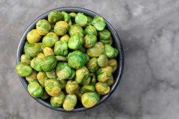 Healthy food green peas in bowl on stone background.