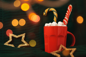 Red mug with hot cocoa and marshmallows on green background. Cozy Christmas home interior. Chocolate with licorice candies. Happy holidays, Merry Xmas, 2023 New Year concept