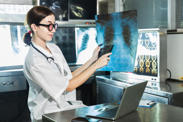 Female doctor check on scan results on monitors in laboratory