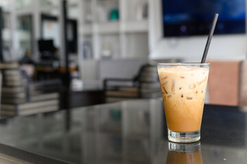 Ice cappuccino coffee with paper straw on black table in modern cafe coffee shop. Coffee Break.