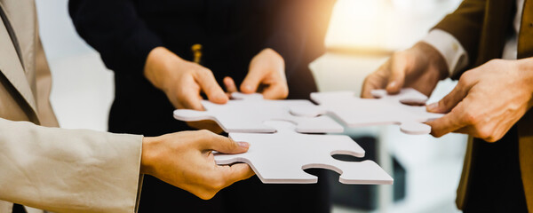hand of successful business people connecting jigsaw puzzle. Business solutions, success and...