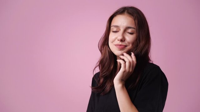 4k video of thoughtful woman on pink background.