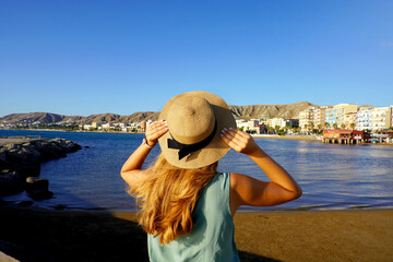 Sunset back view of girl holding straw hat in Crotone city on Calabria coast, Italy © zigres