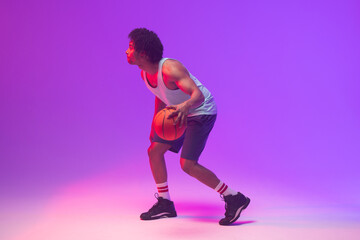 Fototapeta na wymiar Image of biracial basketball player with basketball on neon purple background