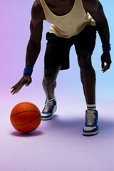 Naklejka premium Image of african american basketball player bouncing basketball on neon purple to blue background