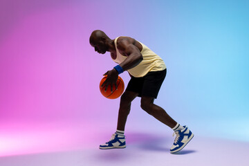 Image of african american basketball player with basketball on neon purple to blue background