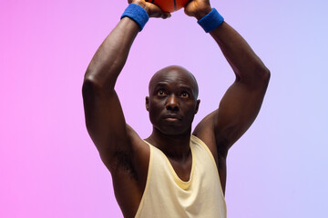Image of african american basketball player with basketball on neon purple to pink background