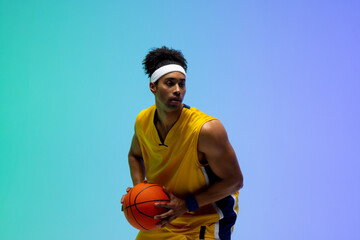 Image of biracial basketball player with basketball on green to blue background - Powered by Adobe