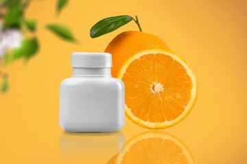 Medical bottle of pills and fresh citrus orange