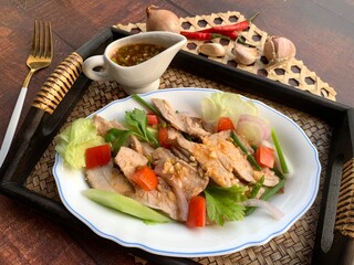 Thai Spicy Grilled Pork Salad - Thai food called Yum Moo Yang or Yum Nuea Yang served in bamboo tray at close up view