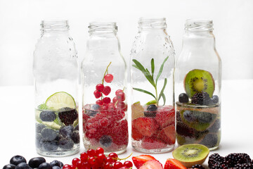 Fototapeta na wymiar Sparkling berries water in glass bottles.