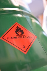 Green drum with red pictogram of a flammable liquid.