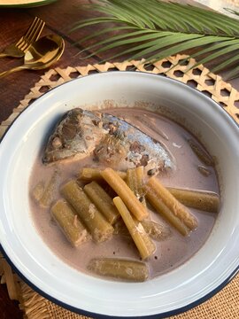 Lotus Stem with Mackerel in coconut soup - Authentic Thai food called Pla too tom Sai Bua close up view on wood table