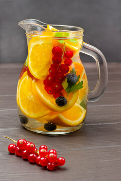 Redcurrant And Orange Infused Water In Glass Jug.