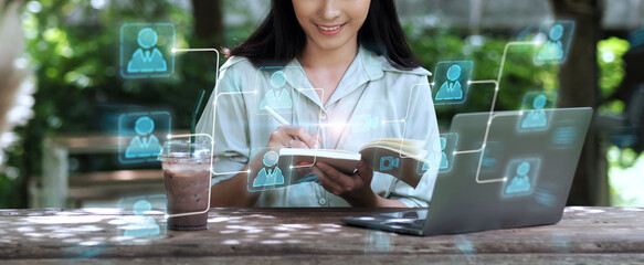 Asian business woman working outdoor with digital wireless online communication technology concept, using  laptop computer portable device working in call meeting with clients writing notebook ideas