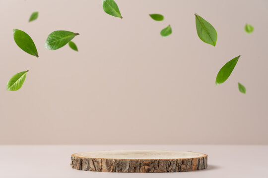Wood slice podium and green flying leaves on white background. Concept scene stage showcase for new product, promotion sale, banner, presentation, cosmetic
