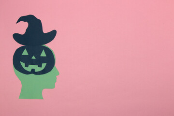 paper head with pumpkin brain and witch hat, creative halloween concept, flat lay, copy space, paper craft
