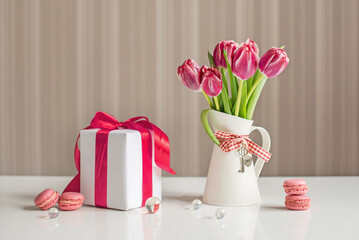 Bouquet of pink tulips with macaroons sweets and gift box