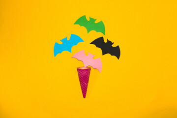 colorful bats pop out of pink ice cream cone, halloween minimal design, creative idea, paper craft

