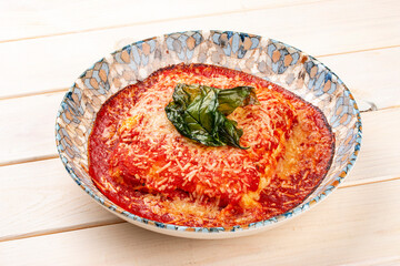 Lasagna in a decorative plate. Italian dish. On a light background.
