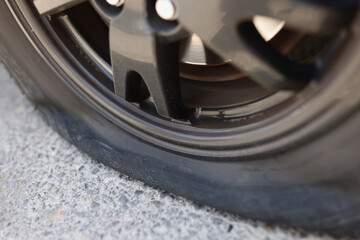 Flat car tire closeup and punctured wheel